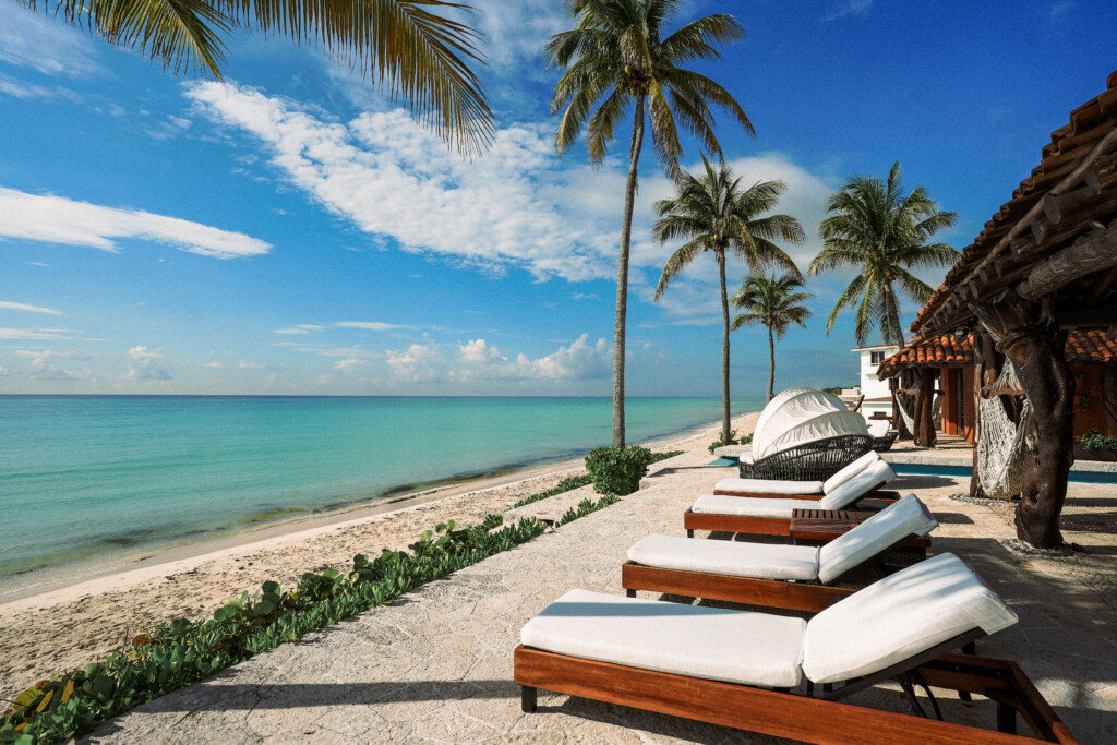 Playa privada con camastros y palmeras frente a Casa Corazón, villa de lujo en Playacar